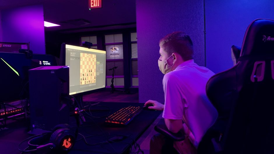 Cole Blakeman is monitored by judges through a video camera while he moves virtual chess pieces across a computer screen. Mizzou Esports offered up their space for Mizzou Chess to compete.